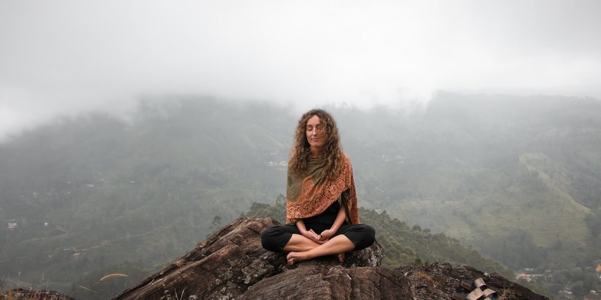 Woman Meditation on top of a Mountain